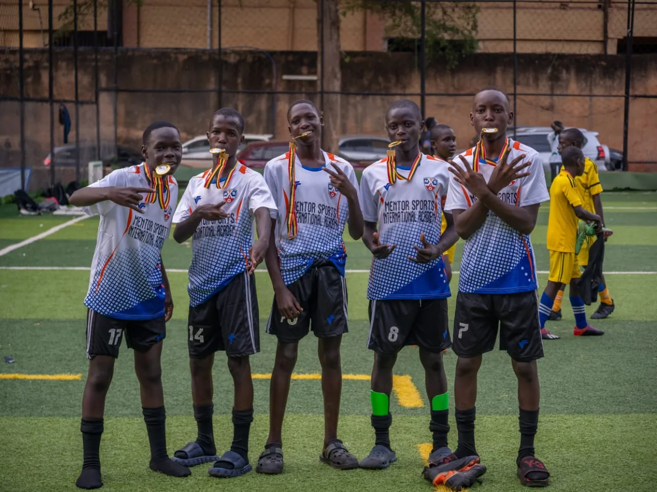 Five academy players celebrating with gold medals