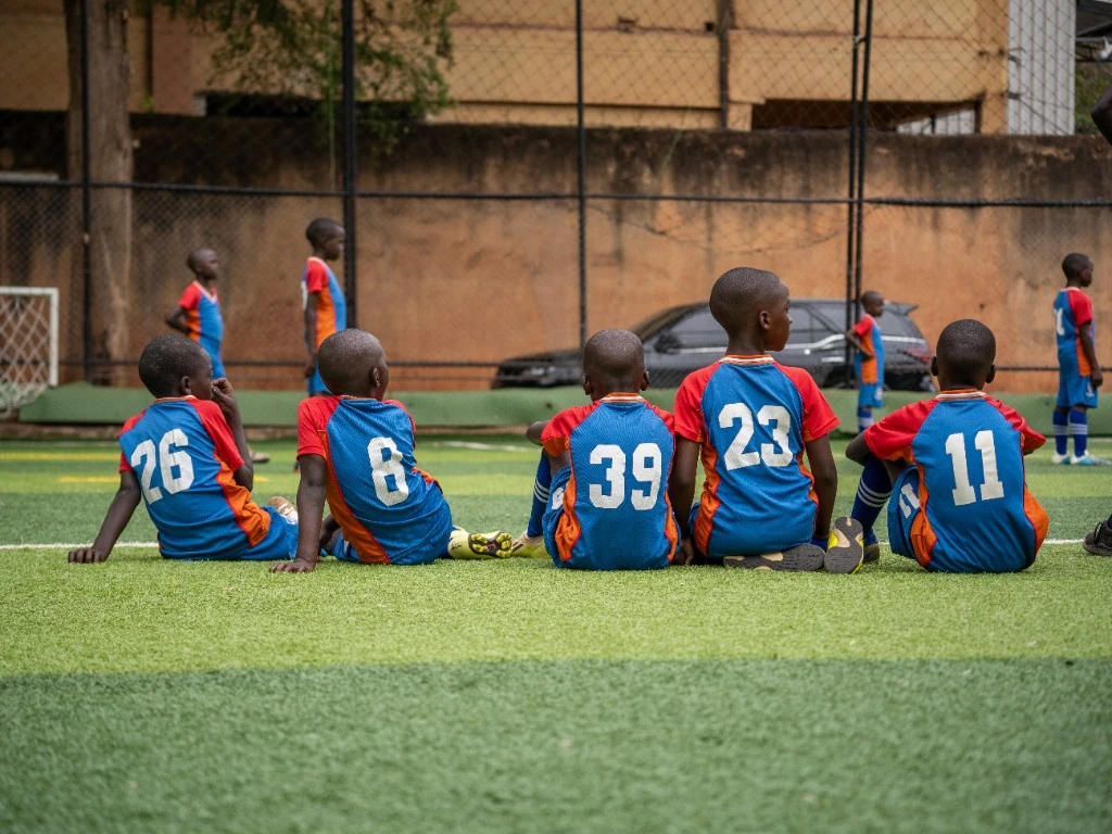 Academy players seated on the pitch